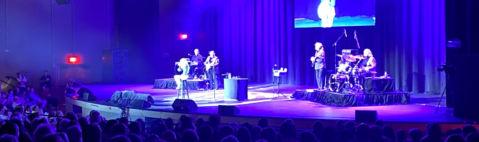 signer on stage in chair washed out by the lights Colorado Springs